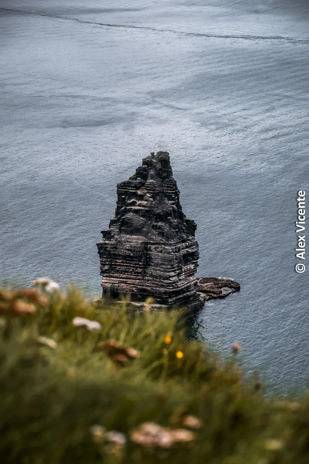 A solitary rock formation rising from the ocean.