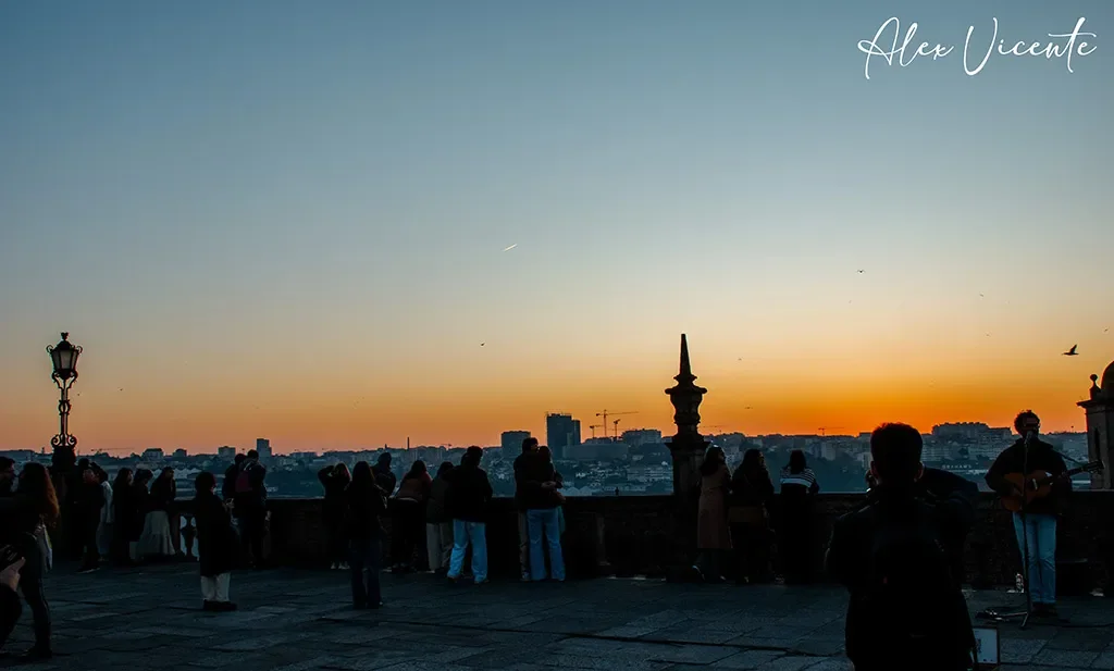 Un músico acompaña el atardecer en Oporto mientras la ciudad se despide del día.